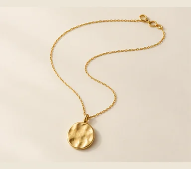 Fine gold-tone chain with a small circular pendant