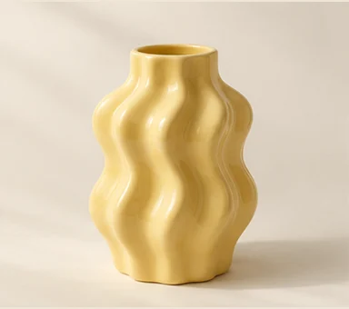 Butter-yellow ceramic vase with a wavy sculptural shape